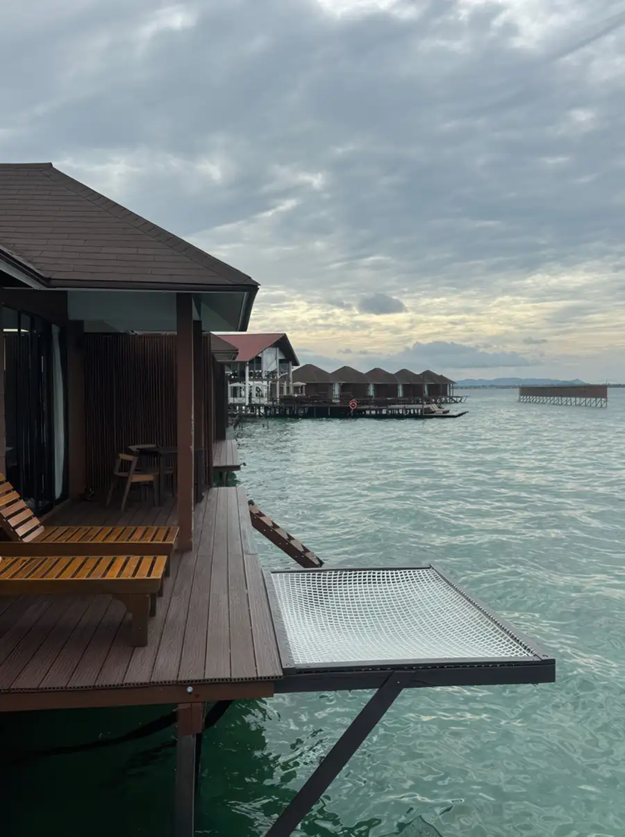 Direct view of a private overwater hammock net suspended over turquoise waters at Sea Star Resort. A barefoot luxury retreat offering the perfect spot for a midday nap in the sun.